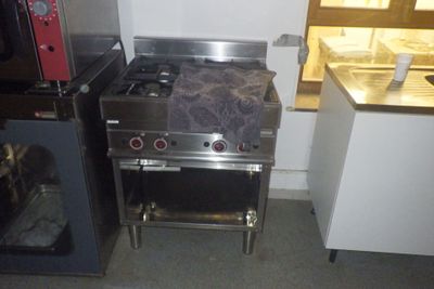 une cuisinière et un four dans une petite cuisine équipée d'un micro-ondes