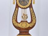 une horloge sous un dôme en verre, posée sur un socle en bois