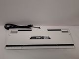 a white laptop computer sitting on a table with a power cord