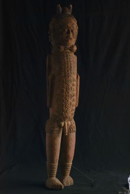 statue d'un homme debout devant un fond noir