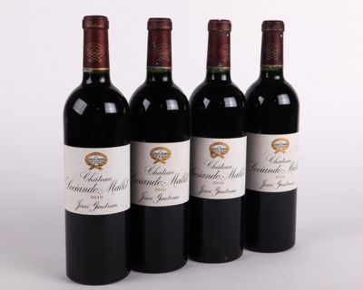 three bottles of red wine are lined up on a white surface
