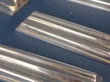 several pieces of silverware are lined up on a blue surface
