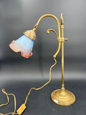 une lampe de table en laiton ancien avec un abat-jour bleu sur fond noir