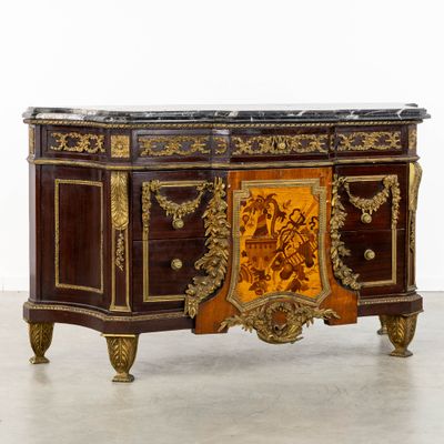 une armoire en bois très ouvragée, surmontée d'un plateau en marbre