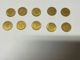 a bunch of gold coins sitting on top of a white table