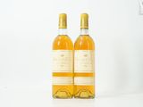 deux bouteilles de vin posées l'une à côté de l'autre sur une surface blanche