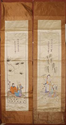 two chinese scroll paintings on display in a room