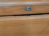 a close up of a wooden drawer with a screw on it