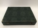 an old green suitcase sitting on top of a white table