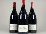 three bottles of red wine sitting on top of a table