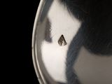 a close up of a silver plate with a small triangle on it