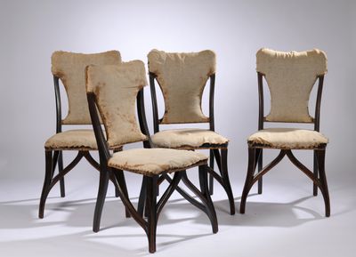 quatre chaises aux assises rembourrées, alignées sur un fond blanc
