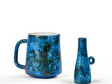 deux vases bleus posés l'un à côté de l'autre sur une surface blanche