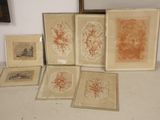 five framed pictures on a table with a mirror in the background