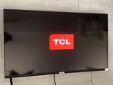 a television on the wall with a tcl logo on it