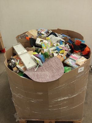 un grand carton rempli d'articles divers, posé sur une palette