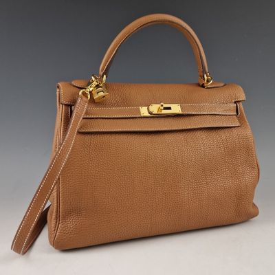 un sac à main en cuir marron avec des ferrures dorées sur la poignée