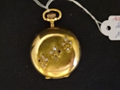 une montre de poche en or sertie de diamants, posée sur un fond noir