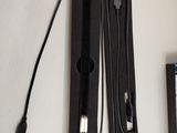 a remote and a charger sitting on a table next to a laptop