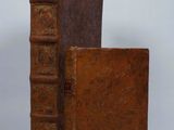 an old book sitting on top of a brown book case
