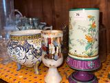 many vases and cups on a shelf in a room