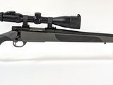 un fusil équipé d'une lunette de visée, posé sur un support transparent