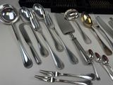 a lot of silver spoons and forks on the table