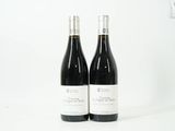 deux bouteilles de vin posées l'une à côté de l'autre sur une surface blanche
