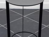 a black table with a glass top sitting on a tiled floor