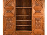 une vieille armoire en bois dont les portes et les étagères sont ornées de sculptures