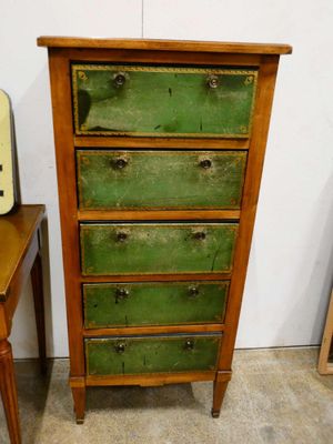 a tall green chest of drawers next to a small table