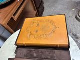 a brown book sitting on top of a table next to other books