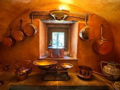 pots and pans are hanging on a wall in a kitchen