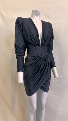 Le mannequin porte une robe noire à manches longues.