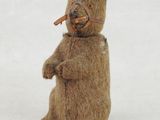 un ours en peluche qui tient un morceau de bois dans la bouche