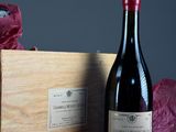une bouteille de vin posée à côté d'une caisse en bois