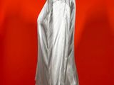a white shirt on a mannequin stand against a red wall
