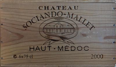 une caisse en bois sur laquelle est accrochée une pancarte indiquant « Château Soccando Mallet Haut-Médoc »
