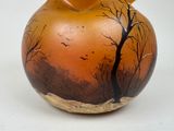 a vase with a picture of a tree and birds painted on it