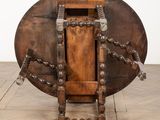 an old wooden table with a chain around it on a tile floor