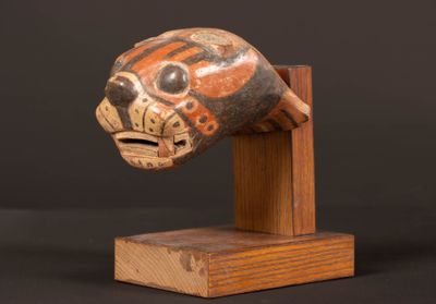 une photo d'une sculpture en bois représentant un chat, posée sur un socle
