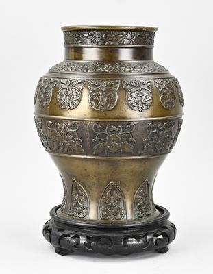 un grand vase en métal avec son socle, sur fond blanc