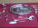 une table recouverte d'une nappe rouge et sur laquelle sont disposés des couverts