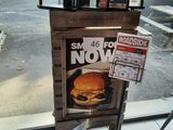 a newspaper dispenser with a sandwich on it