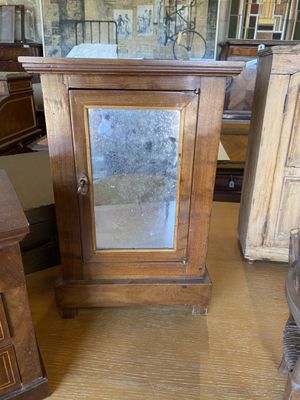 une petite armoire en bois surmontée d'un miroir