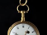 an image of a gold pocket watch with roman numerals on the face