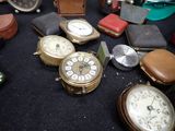many different types of pocket watches on the table