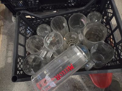 un panier rempli de verres vides et une bouteille d'eau