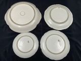 four white plates with lids are sitting on a black surface