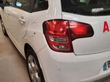 a white car parked in a garage with other cars in the background